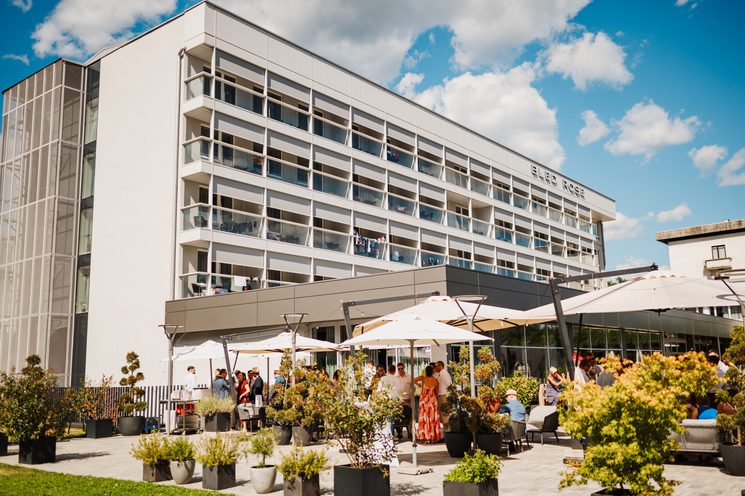 Bled Rose Hotel facade with wedding guests at a terrace aperitif by Lake Bled