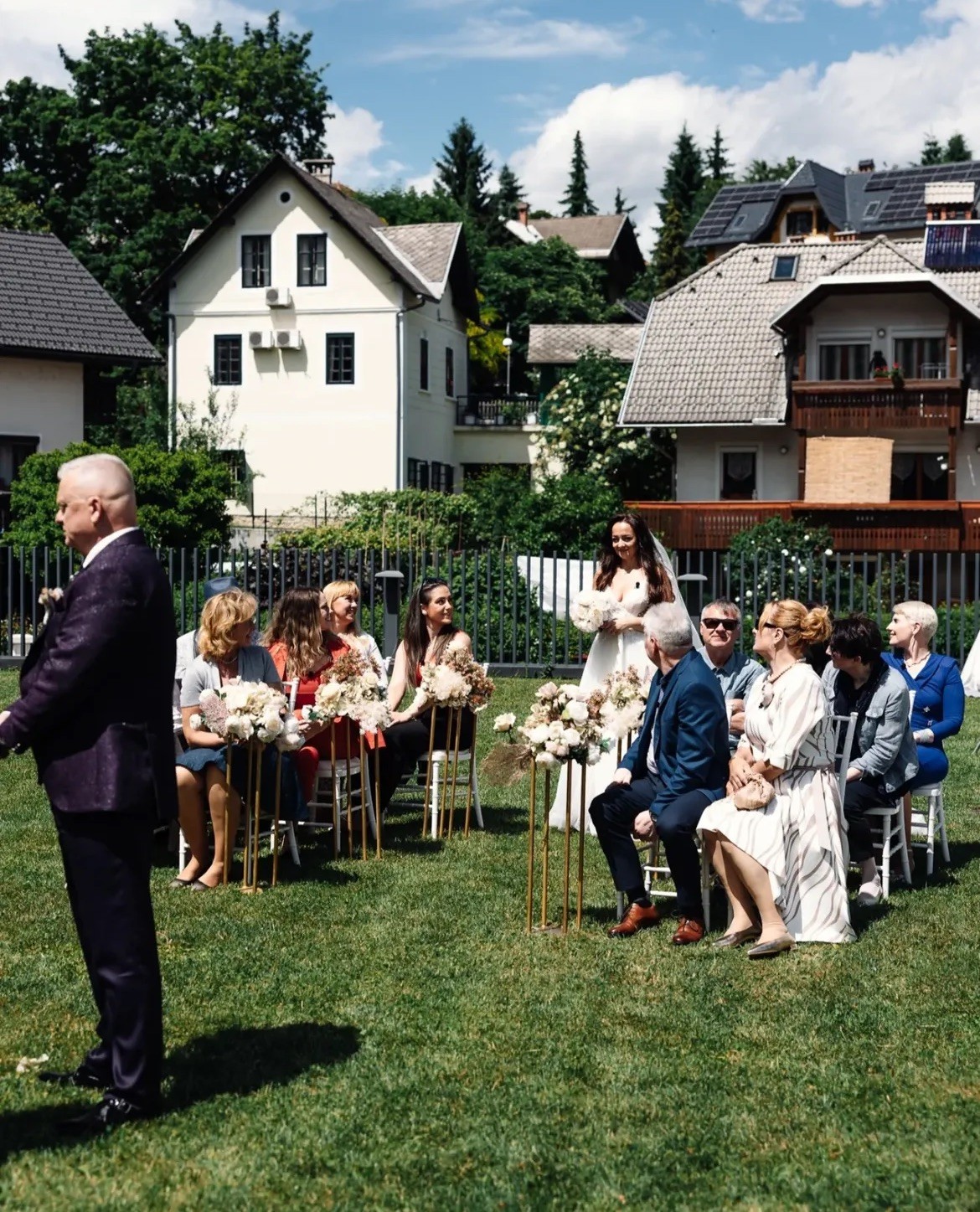 Bride walking down the aisle between guests in the upper garden at Bled Rose Hotel