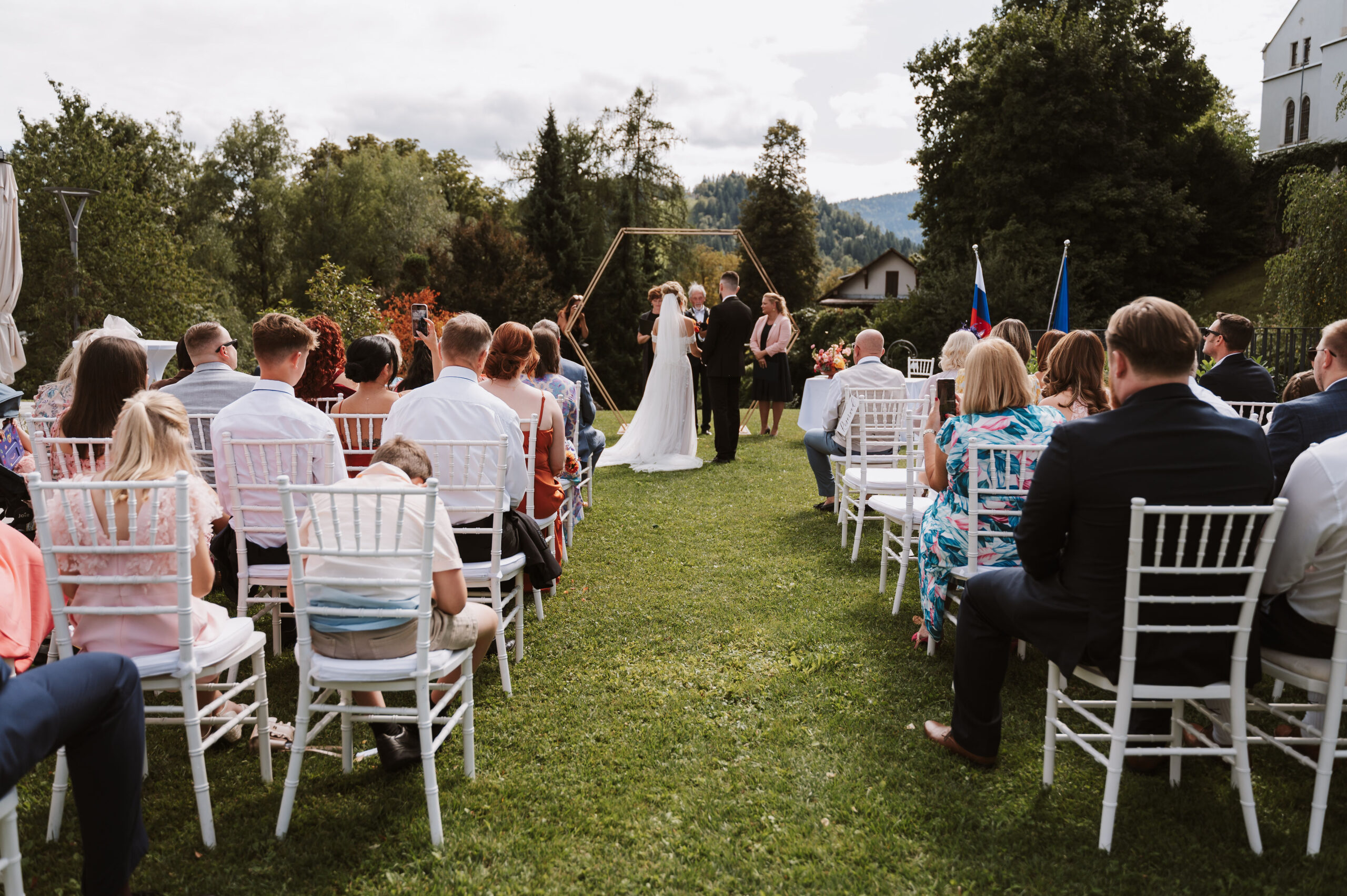Outdoor wedding ceremony in the Bled Rose Hotel garden under a gold hexagonal arch