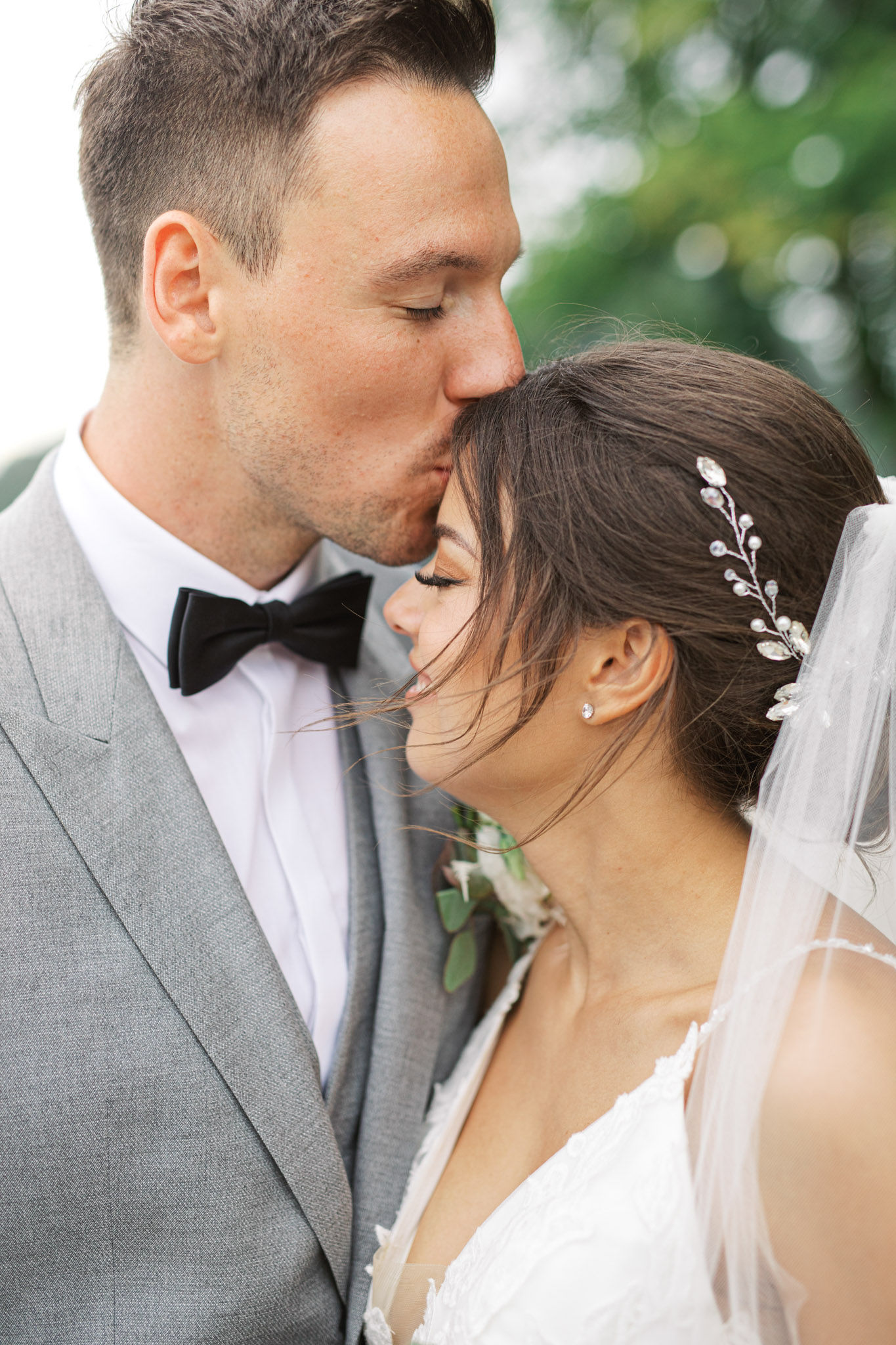 Groom kissing the bride on the forehead