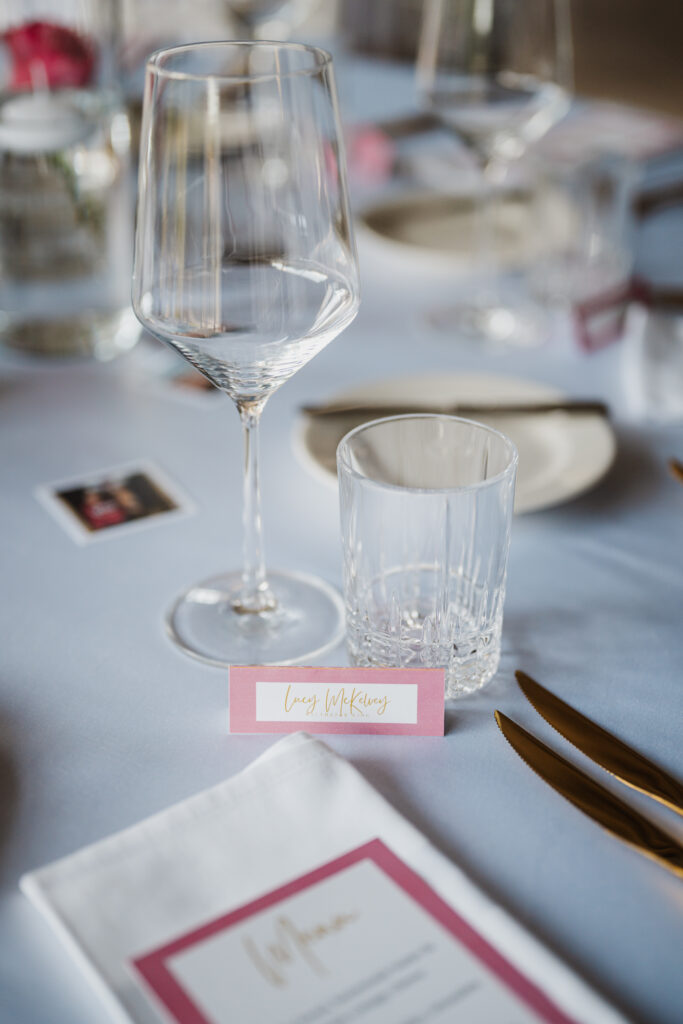 Wedding place setting with a name card and gold cutlery